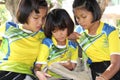 Three girls are watching the interest on a telephone.